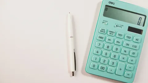 Calculator and pen used to illustrate finance and pre-sale feasibility checks for property development.