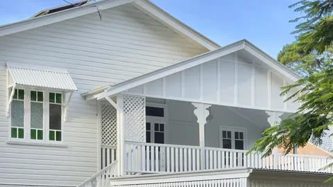 A Queenslander house in Sherwood, Brisbane, white timber with a verandah