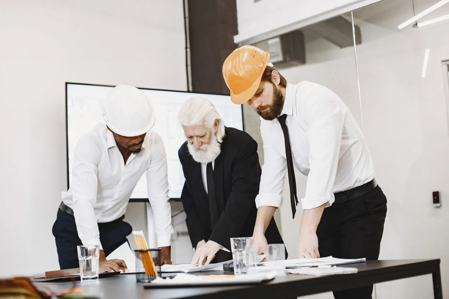 Property professionals comparing architectural plans and project evidence