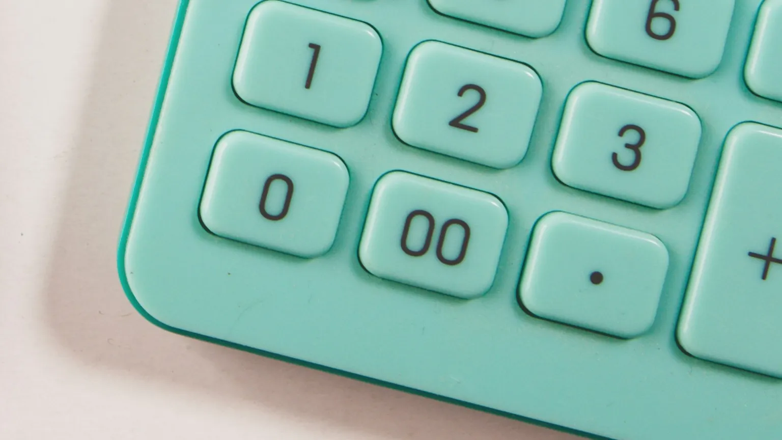 Teal calculator number keys on a pale surface.