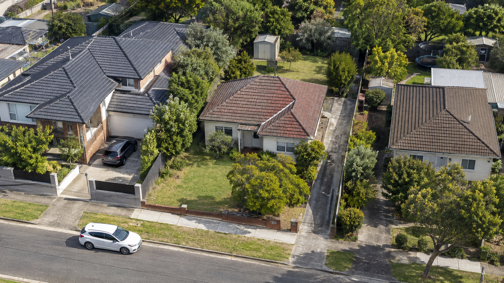 Illustrative aerial view of an Australian suburban block with an existing home, rear yard and side access