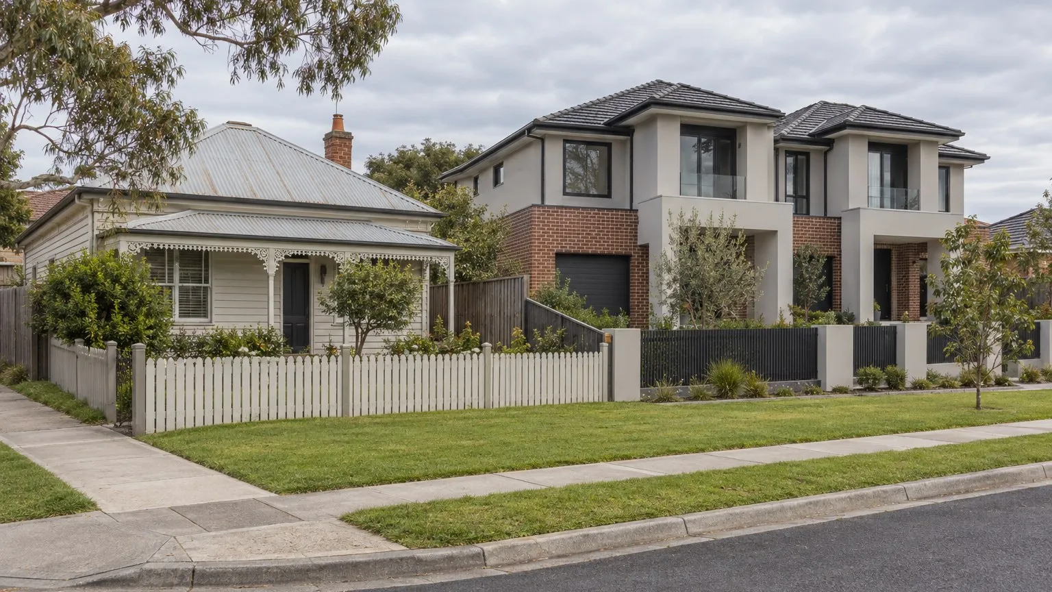 Older single-storey weatherboard cottage next to a newly built two-storey attached dwelling pair on a suburban street behind low front fences