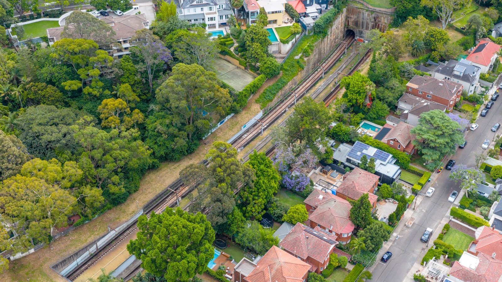 Aerial view of suburban houses beside a railway corridor