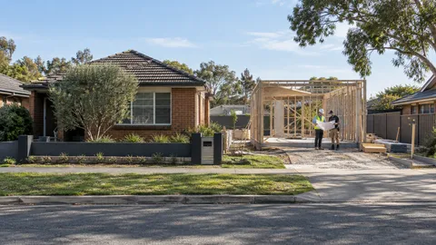 Illustrative Australian infill construction site with an existing home and new timber framing