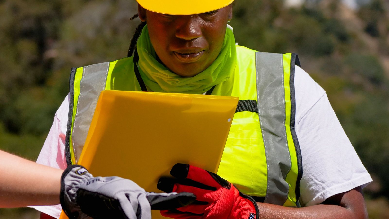 Construction manager updating project costs beside building plans