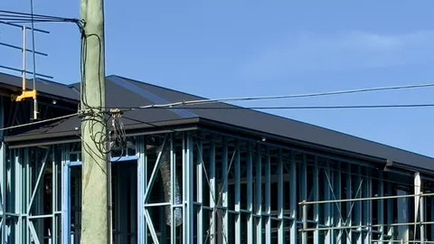 Steel-framed Queensland building under construction with roof and wall framing visible.