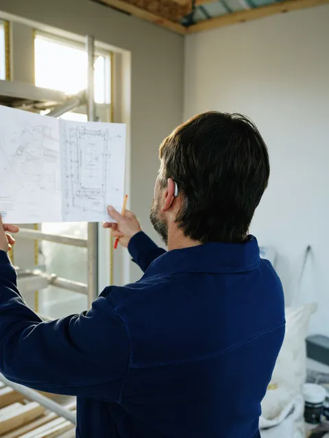 Construction professional reviewing residential building plans on site