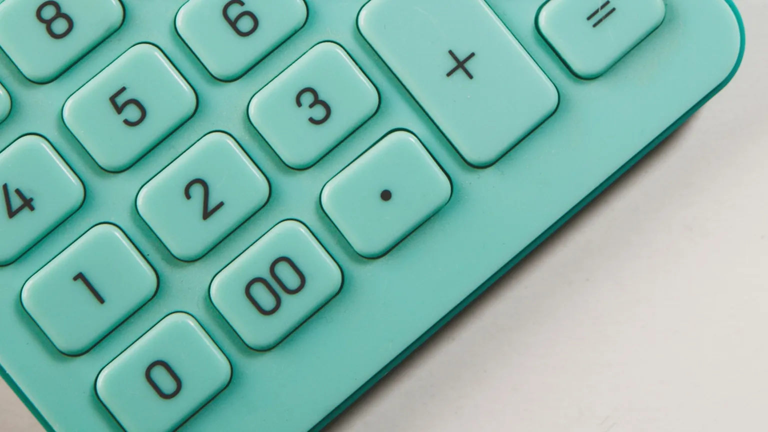 Close-up of teal calculator number keys on a pale surface.