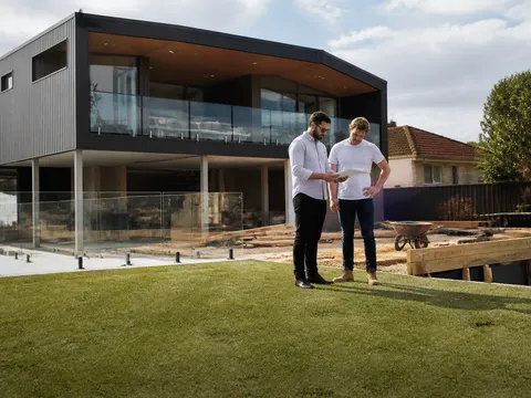 Australian property investor reviewing a contract with a seller across a kitchen table