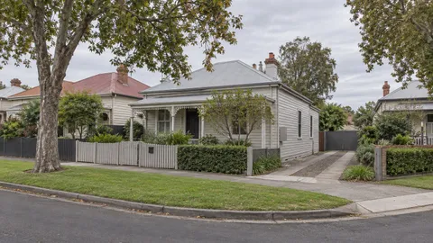 Weatherboard house on a corner block in an older suburban street