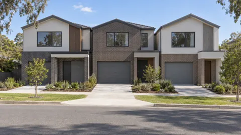 Three attached two-storey infill townhouses seen from across the road