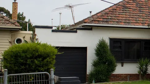 A rendered 1950s house with a tiled roof in Sunshine, Victoria