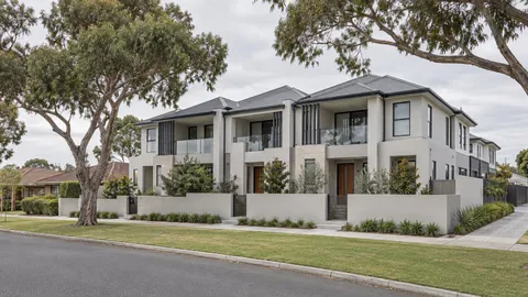 Multi-dwelling development of pale two-storey attached homes on a suburban street