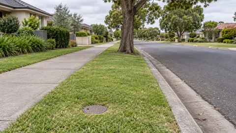 Water main tap and pipework on a suburban verge near the street